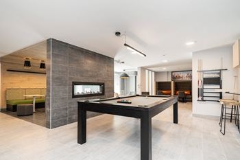 a pool table in a living room with a fireplace